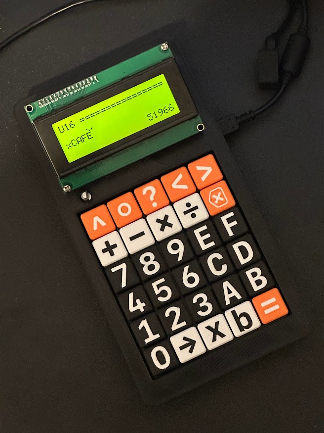 The Delta Radix calculator, assembled into a black 3D-printed case, with a mixture of black, white, and orange buttons. The black-on-green LCD display is showing the calculation "xCAFE", which evaluates to "51966" in decimal.