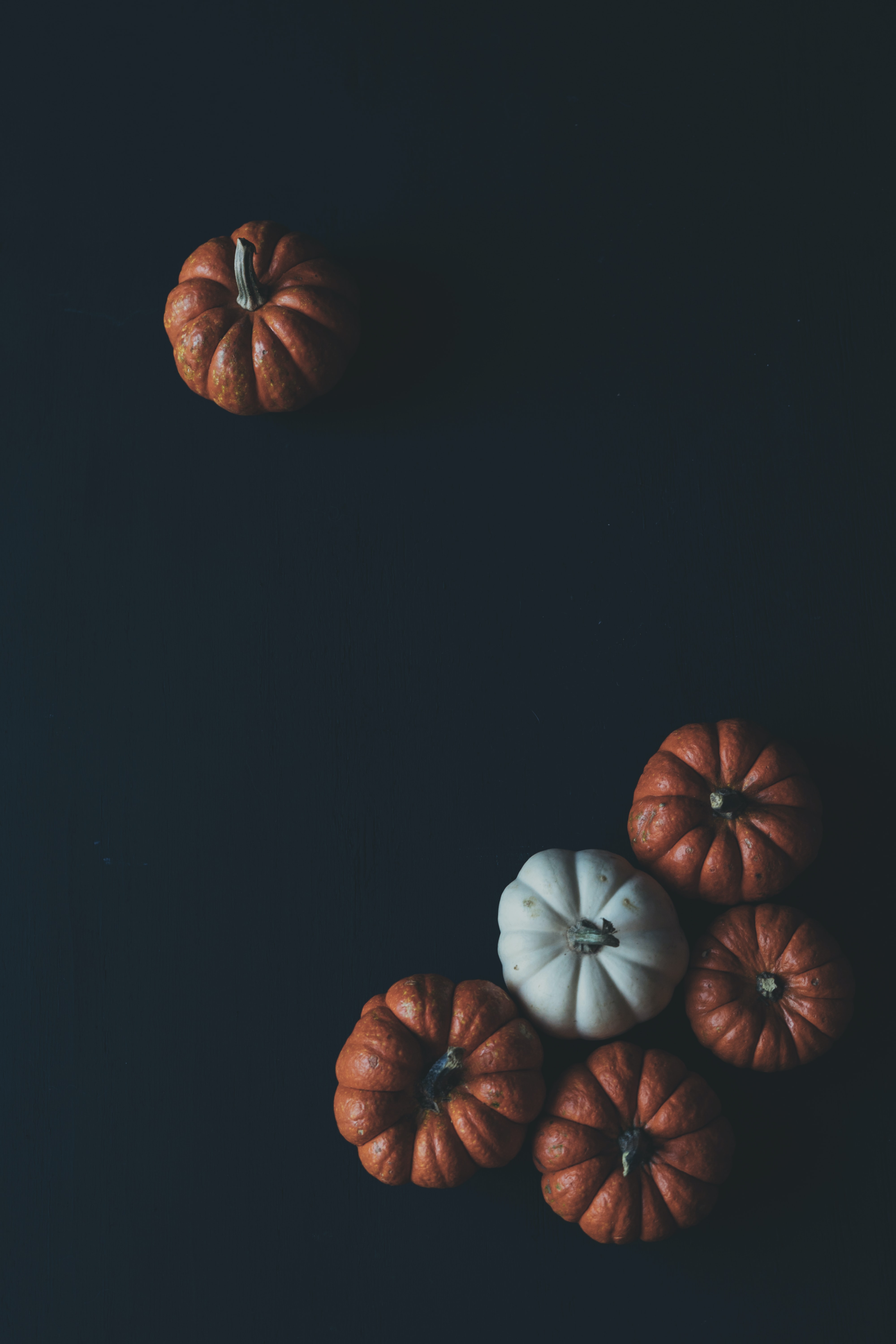 a_group_of_pumpkins_on_a_black_surface