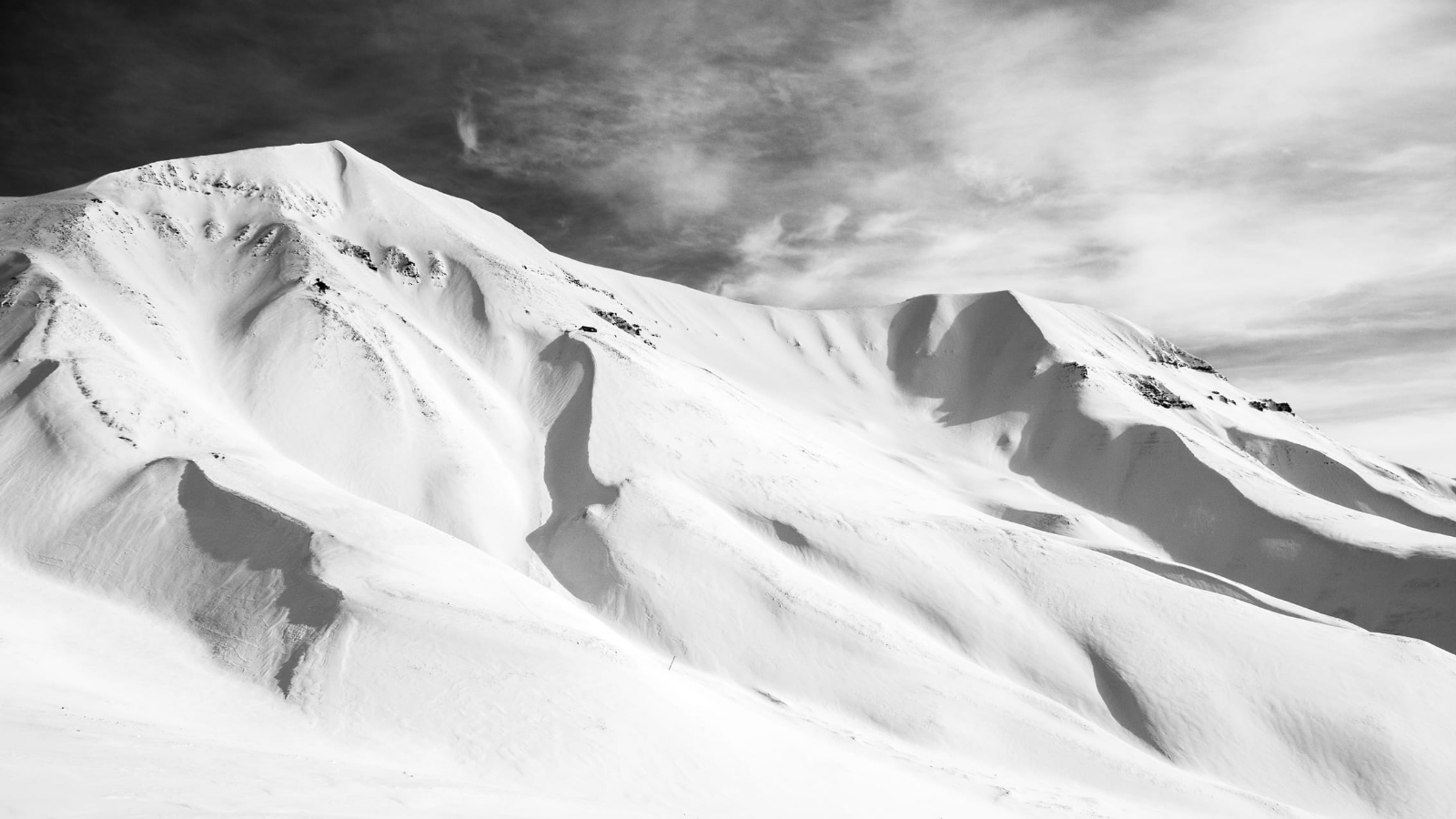 a_snowy_mountain_with_clouds_in_the_sky