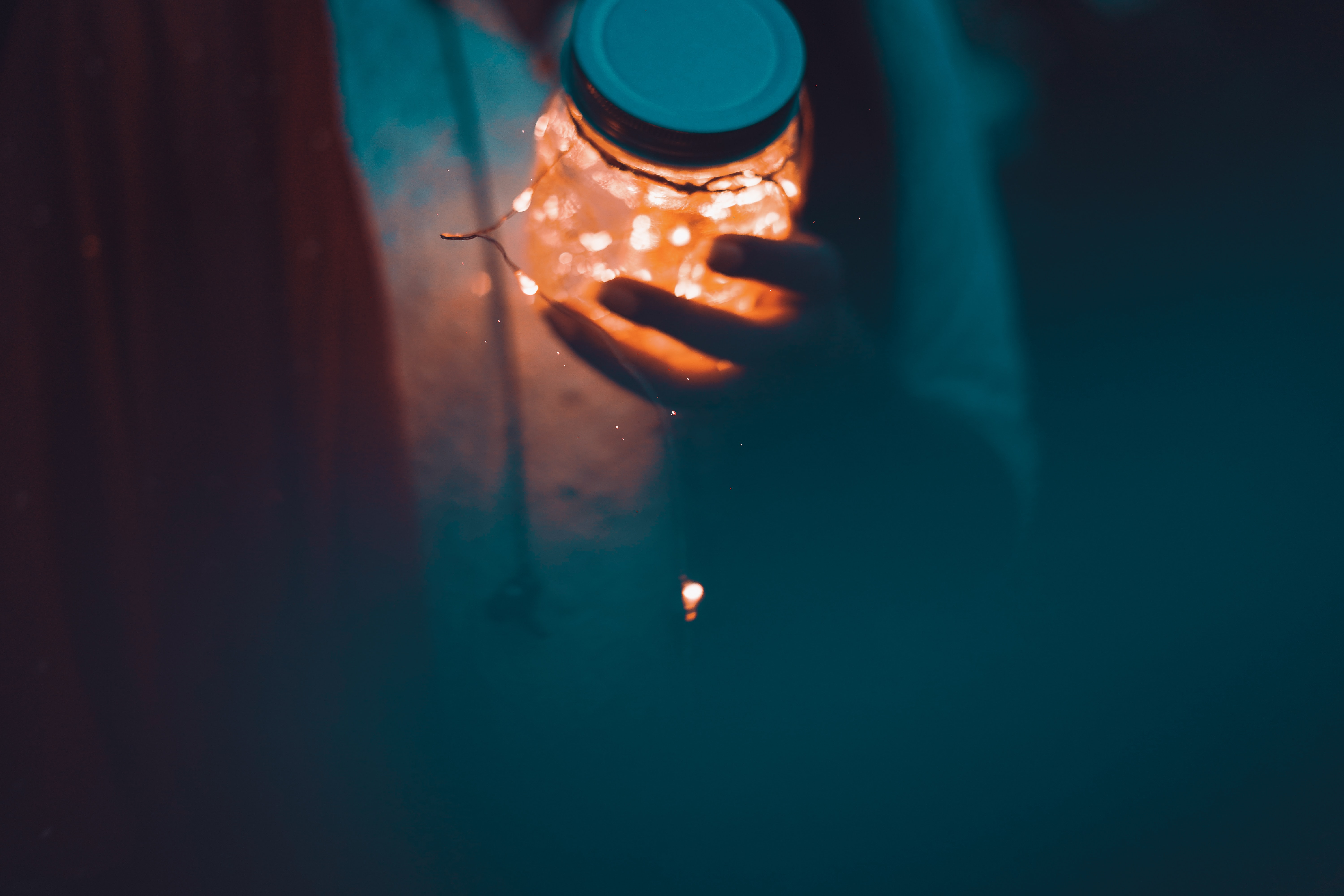 a_person_holding_a_jar_with_lights