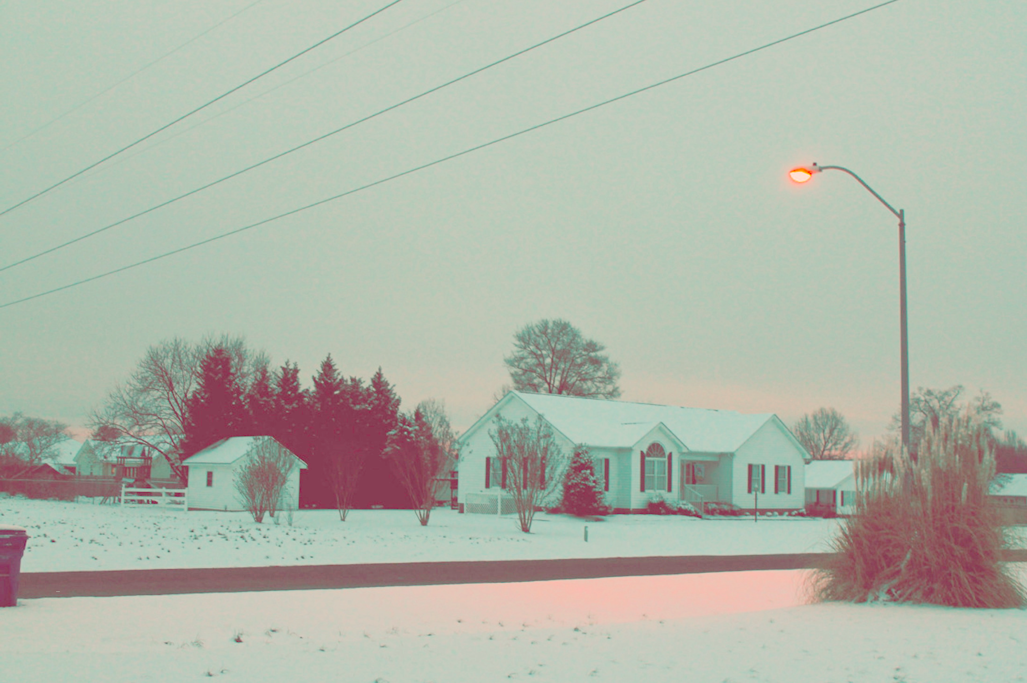 a_snow_covered_houses_and_a_street_light