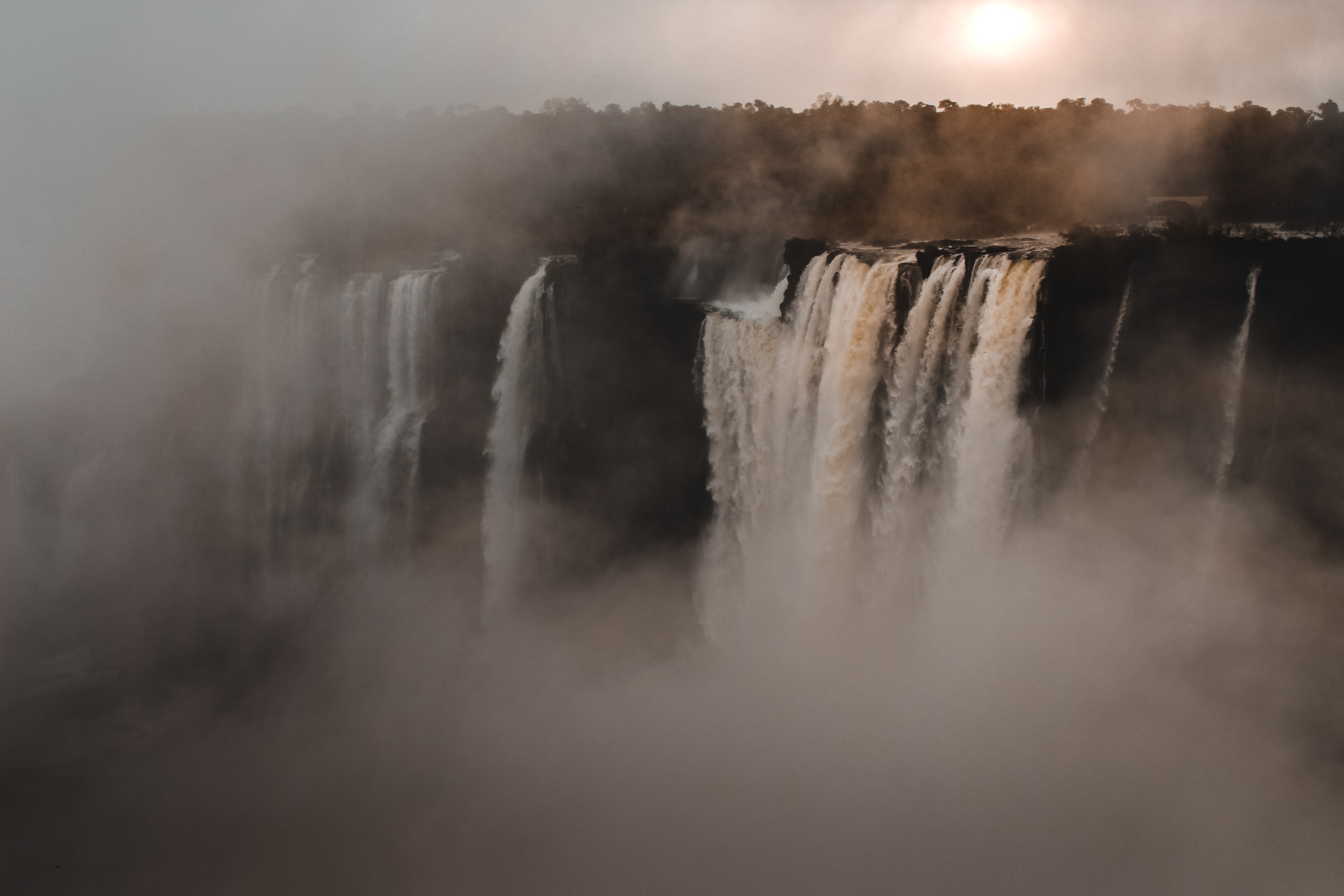 a_large_waterfall_with_fog_and_trees