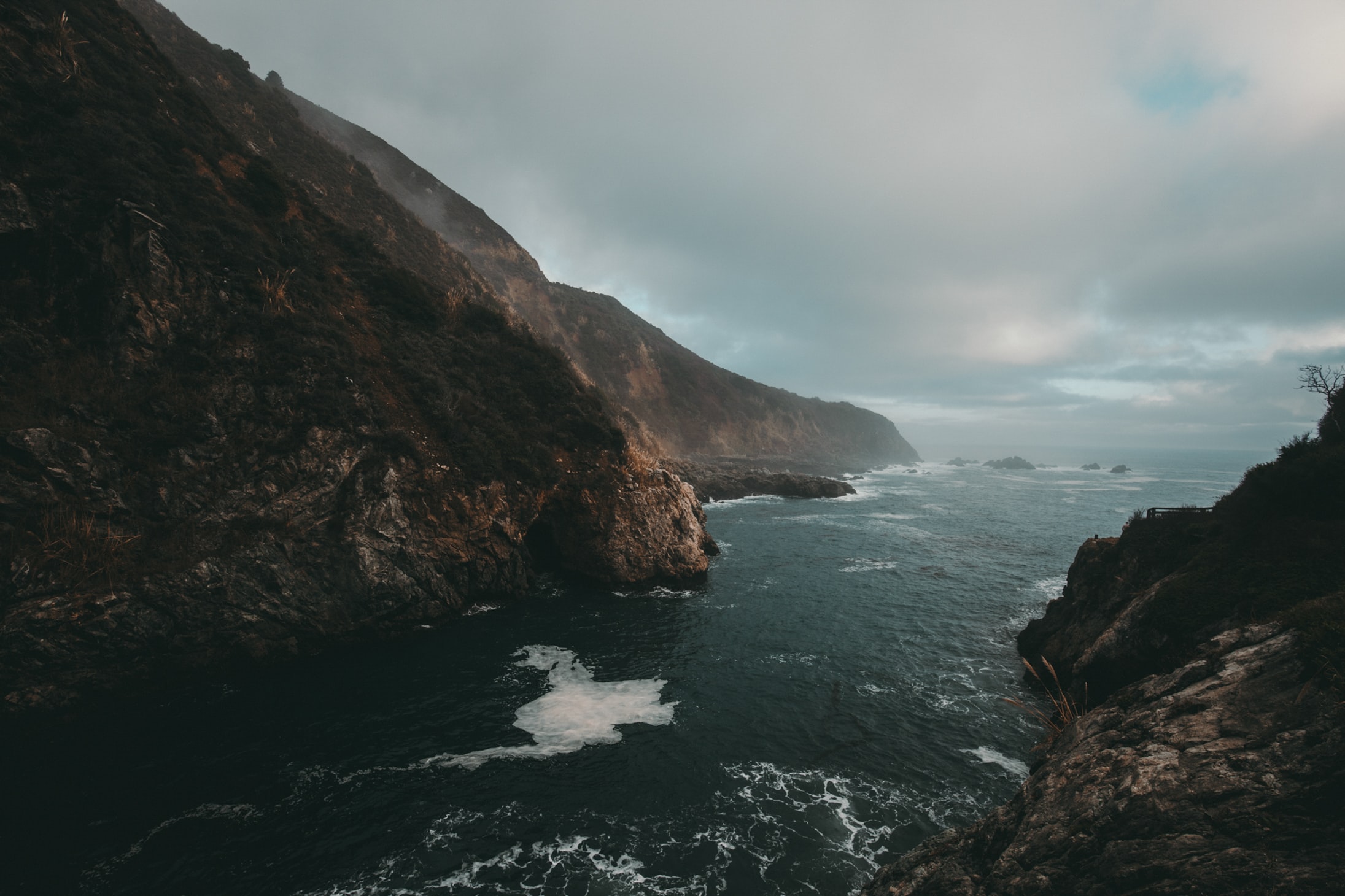 a_body_of_water_with_rocks_and_a_cliff