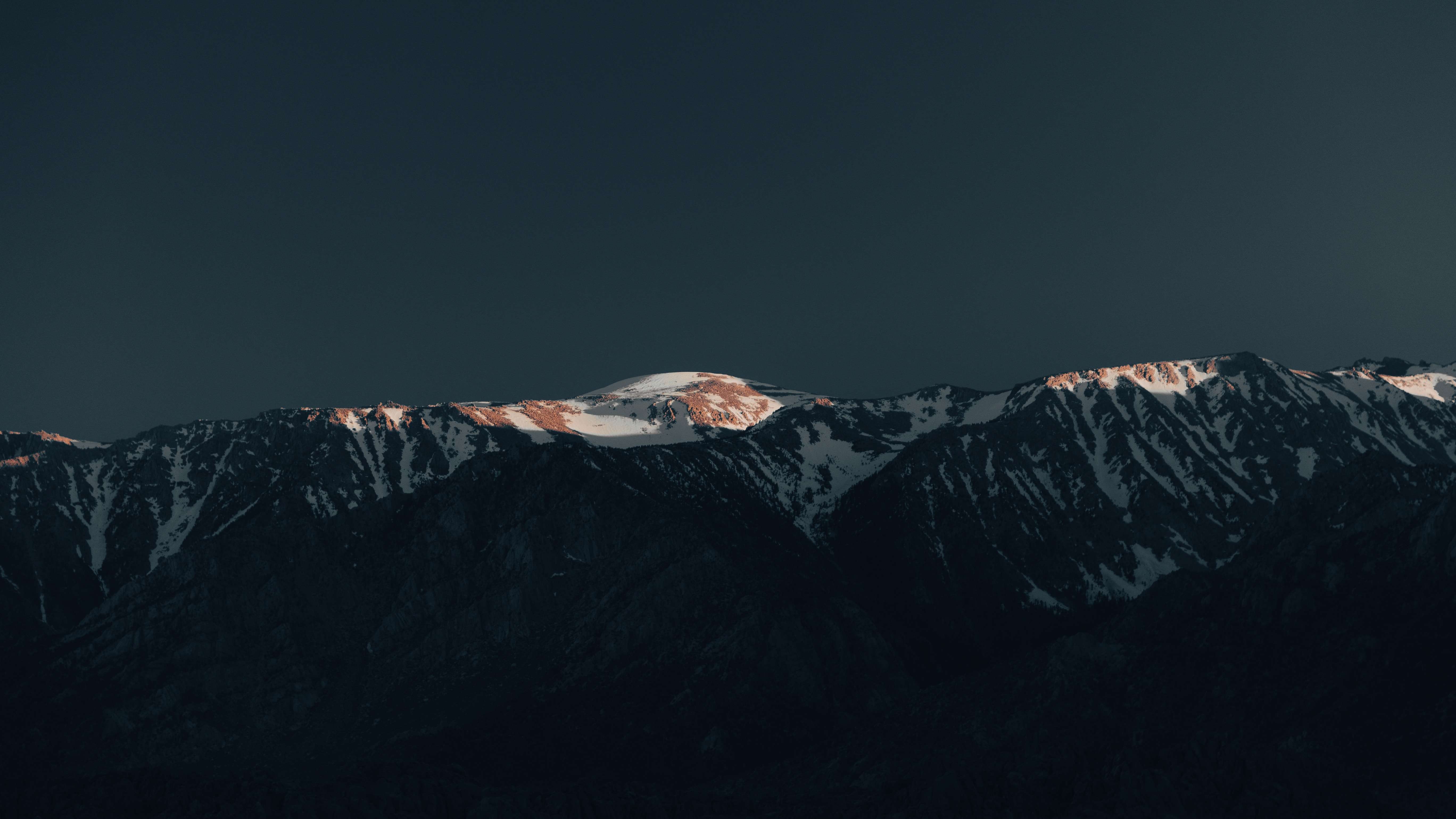 a_snowy_mountain_top_with_dark_sky