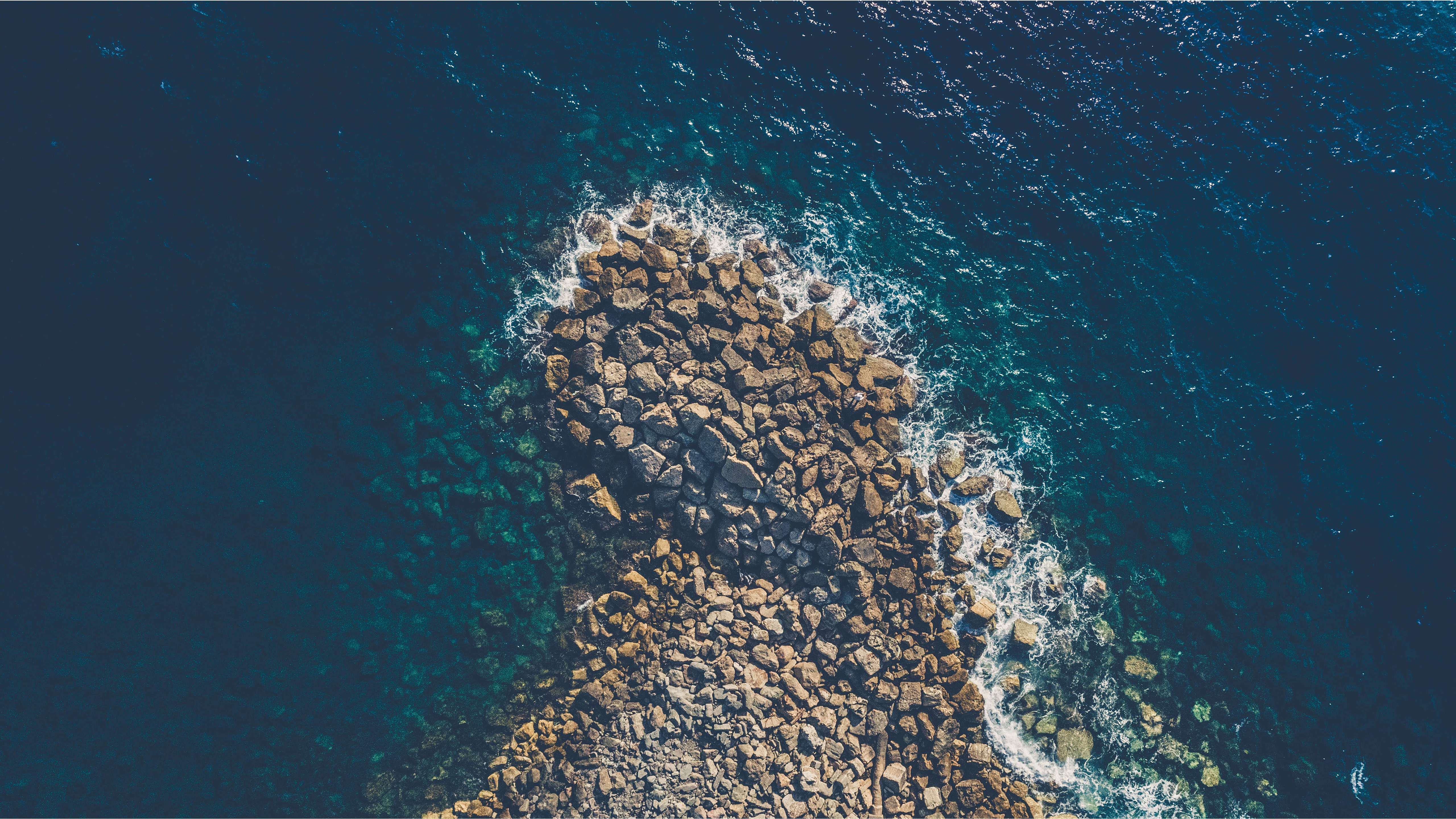 a_rocky_shore_with_waves_crashing_on_it