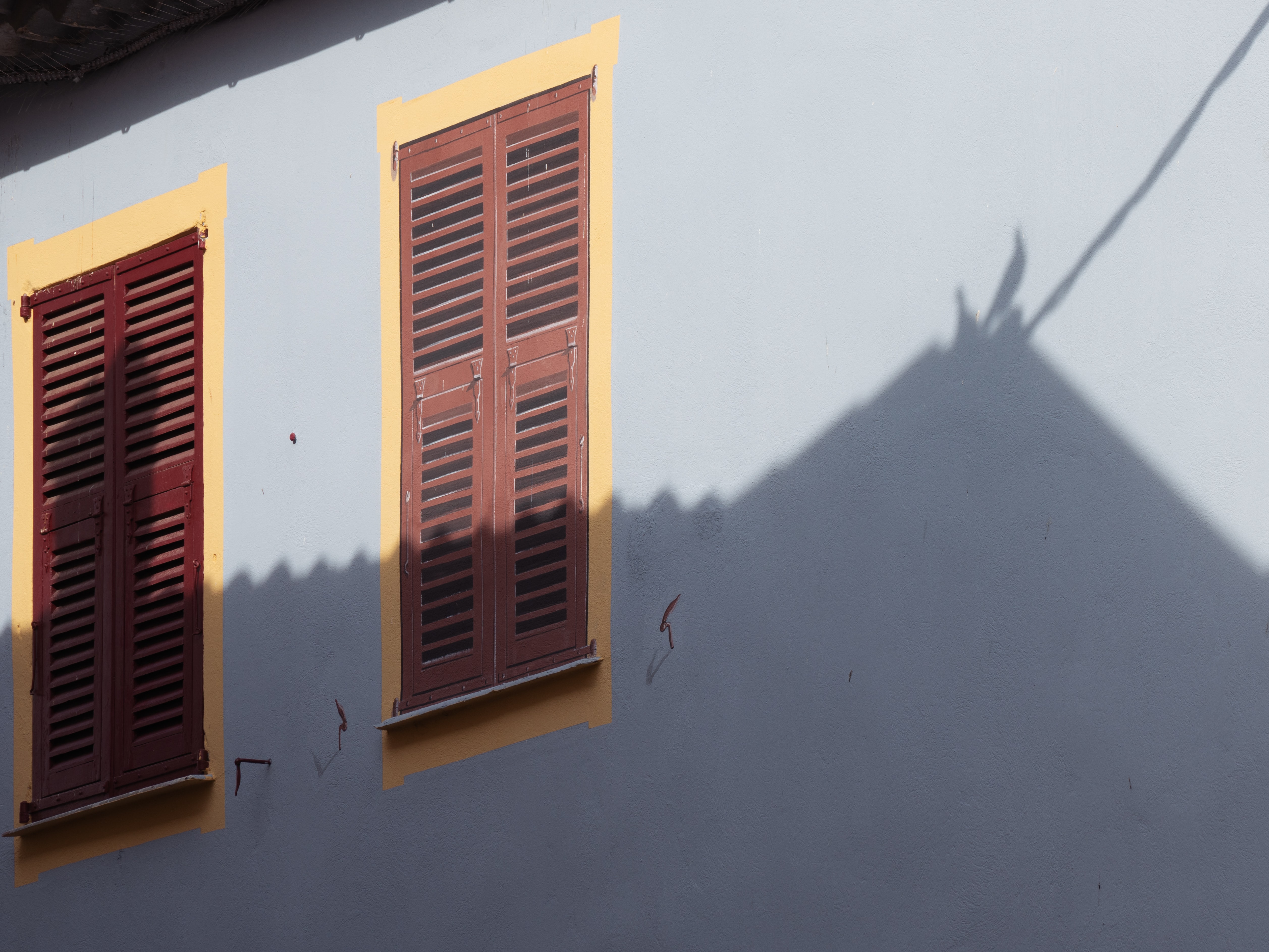 a_building_with_shutters_on_windows