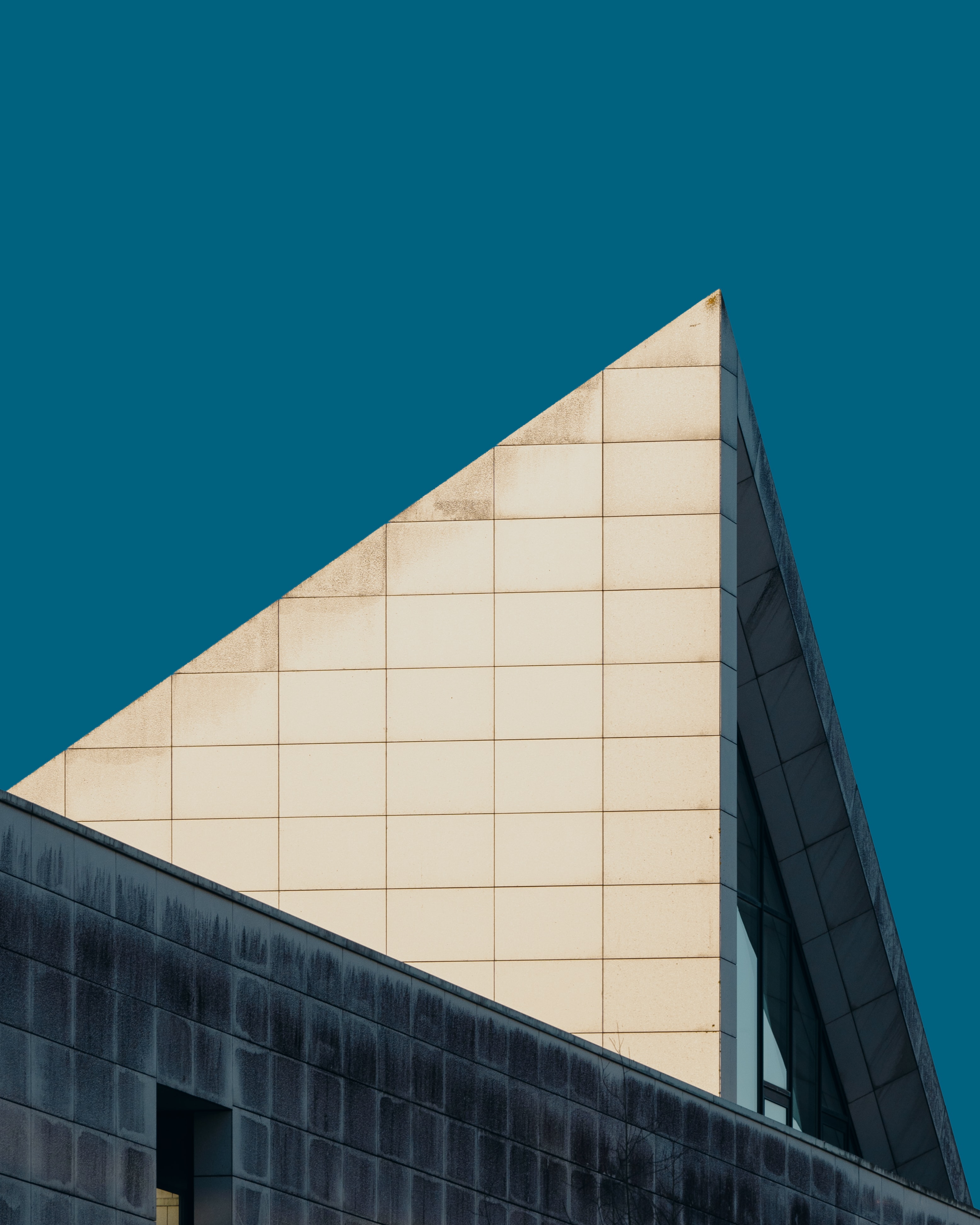 a_triangular_building_with_a_blue_sky