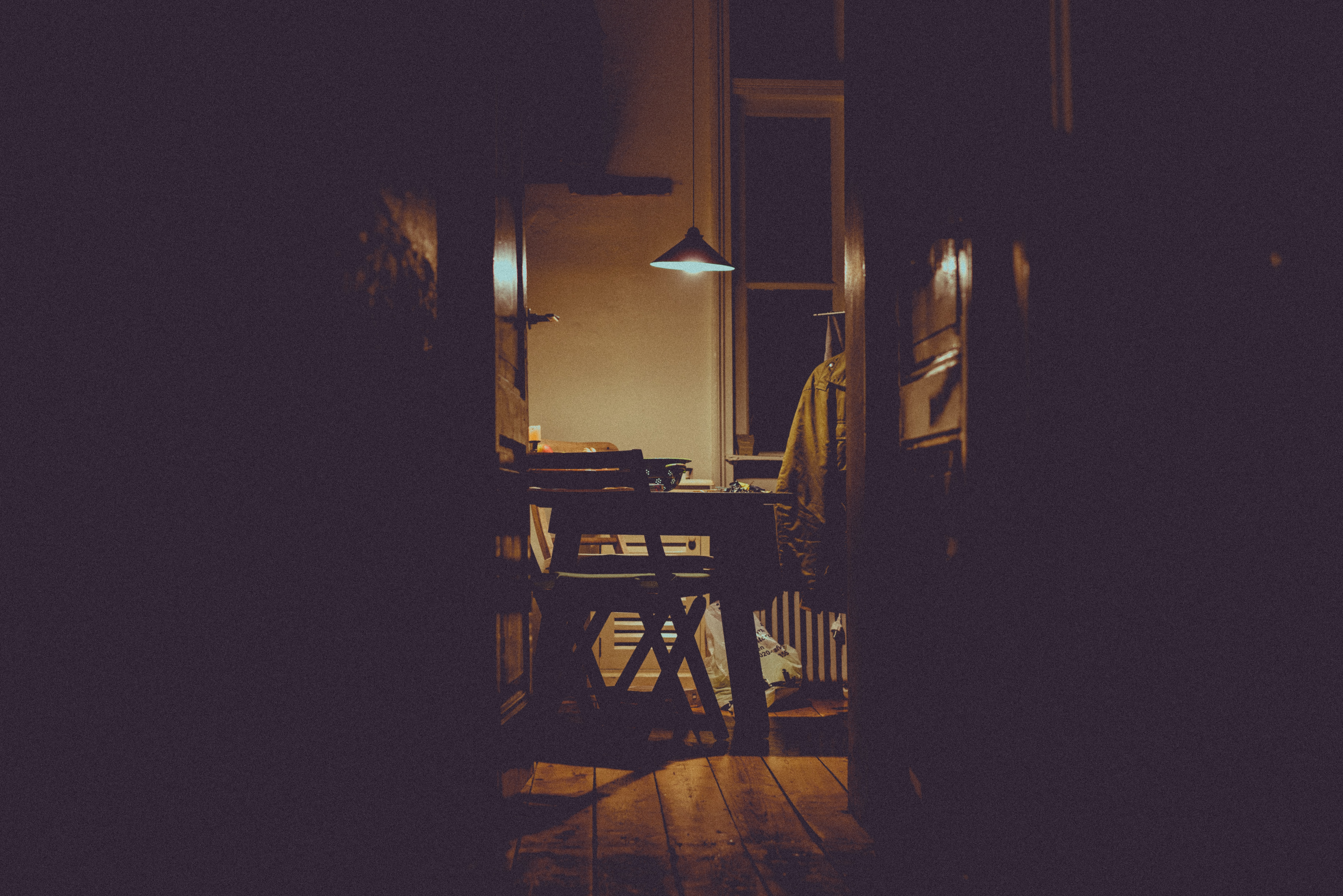 a_dark_room_with_a_table_and_chairs