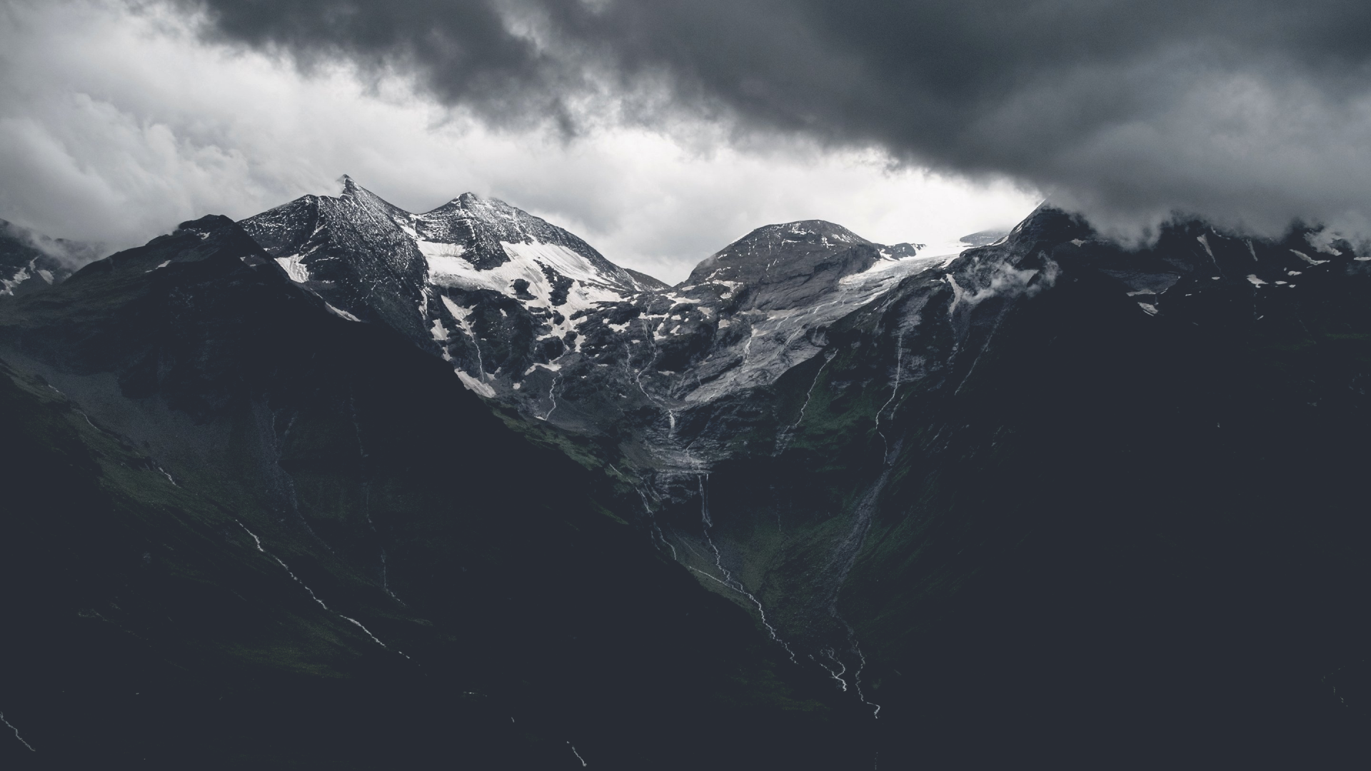 a_snowy_mountain_tops_with_clouds_in_the_background