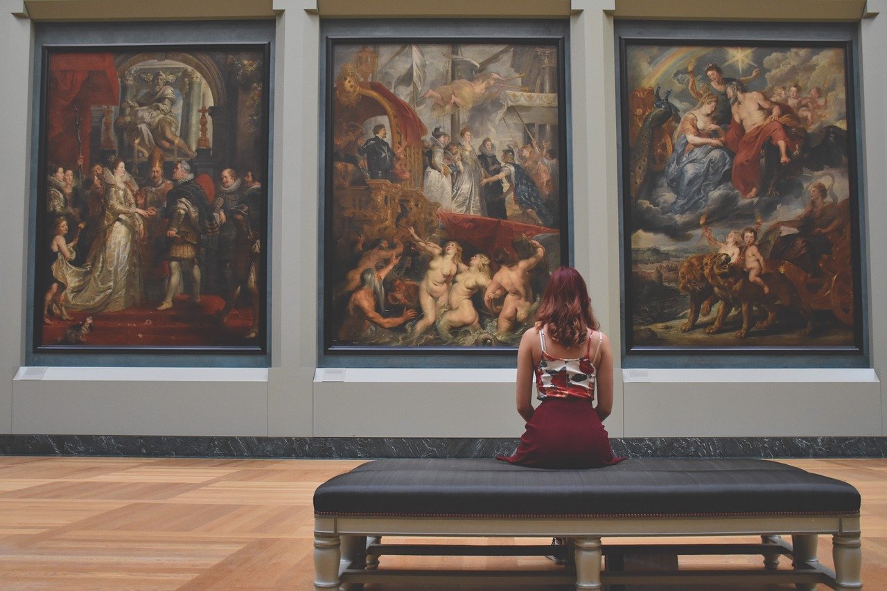 Woman sitting on a bench and viewing paintings by Rubens